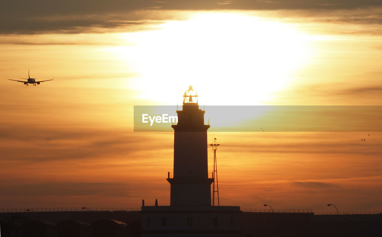 SILHOUETTE LIGHTHOUSE AGAINST SKY DURING SUNSET
