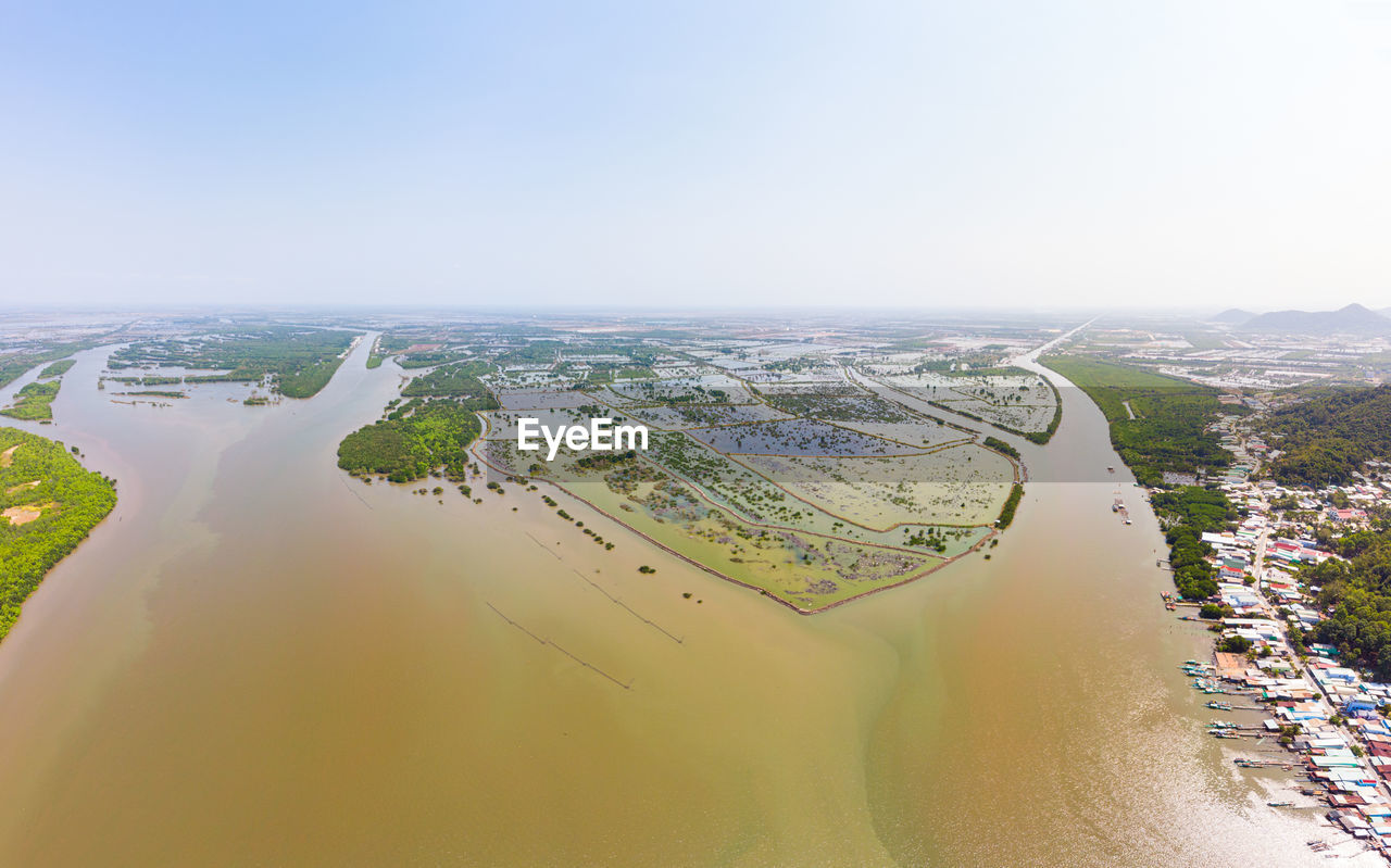 HIGH ANGLE VIEW OF RIVER AMIDST BUILDINGS IN CITY