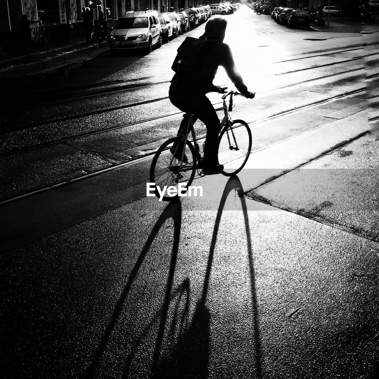 Silhouette man bicycling on road