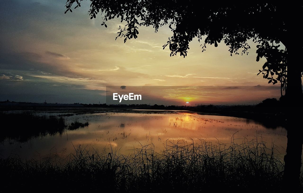 SCENIC VIEW OF LAKE AGAINST SUNSET SKY