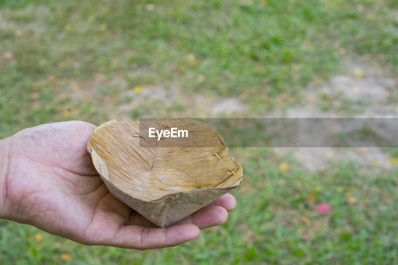 CLOSE-UP OF HAND HOLDING BREAD