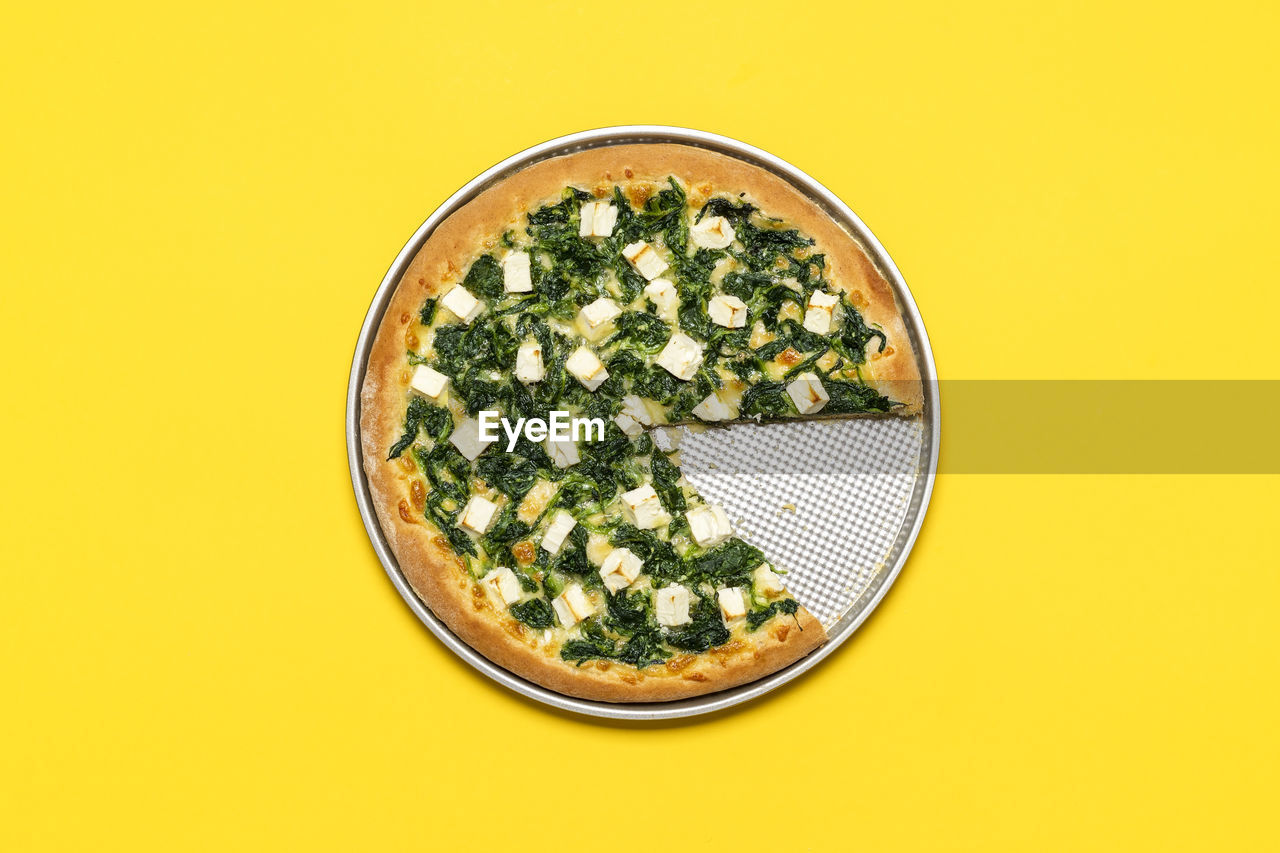 Top view, a vegetarian pizza with spinach, mozzarella, and feta. healthy pizza freshly backed.