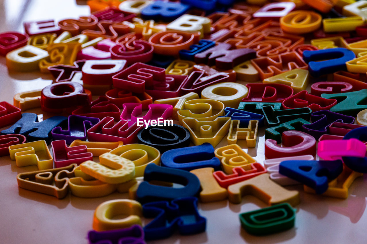 multi colored, large group of objects, variation, indoors, no people, abundance, toy, number, still life, font, high angle view, close-up, letter, text
