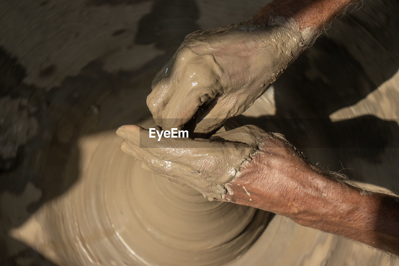 cropped image of man working on pottery wheel