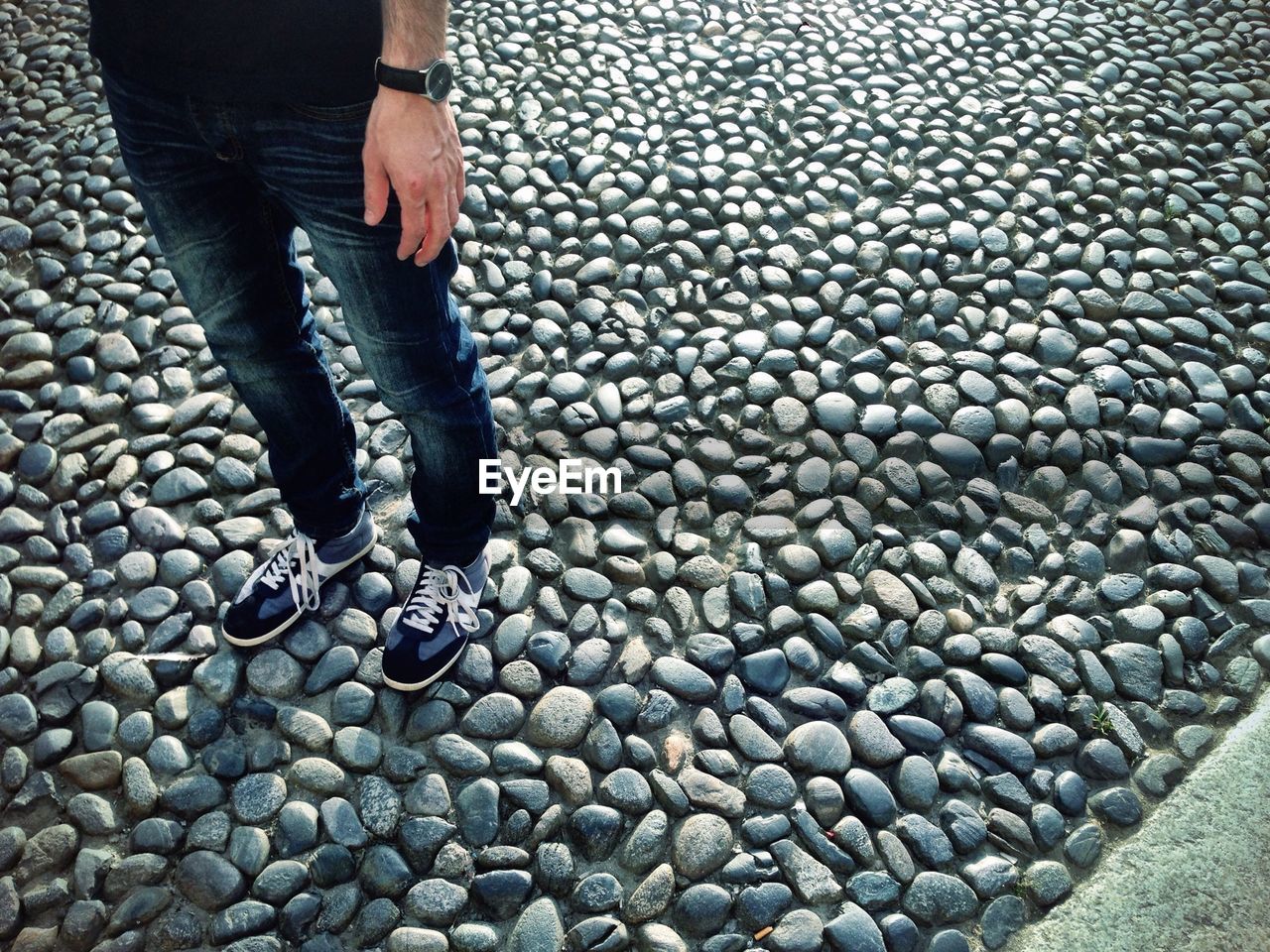 Low section of man standing on cobblestone street in vigevano town