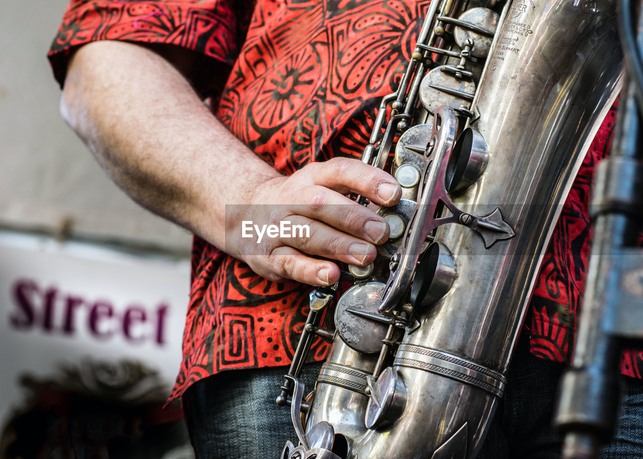 Midsection of man playing saxophone