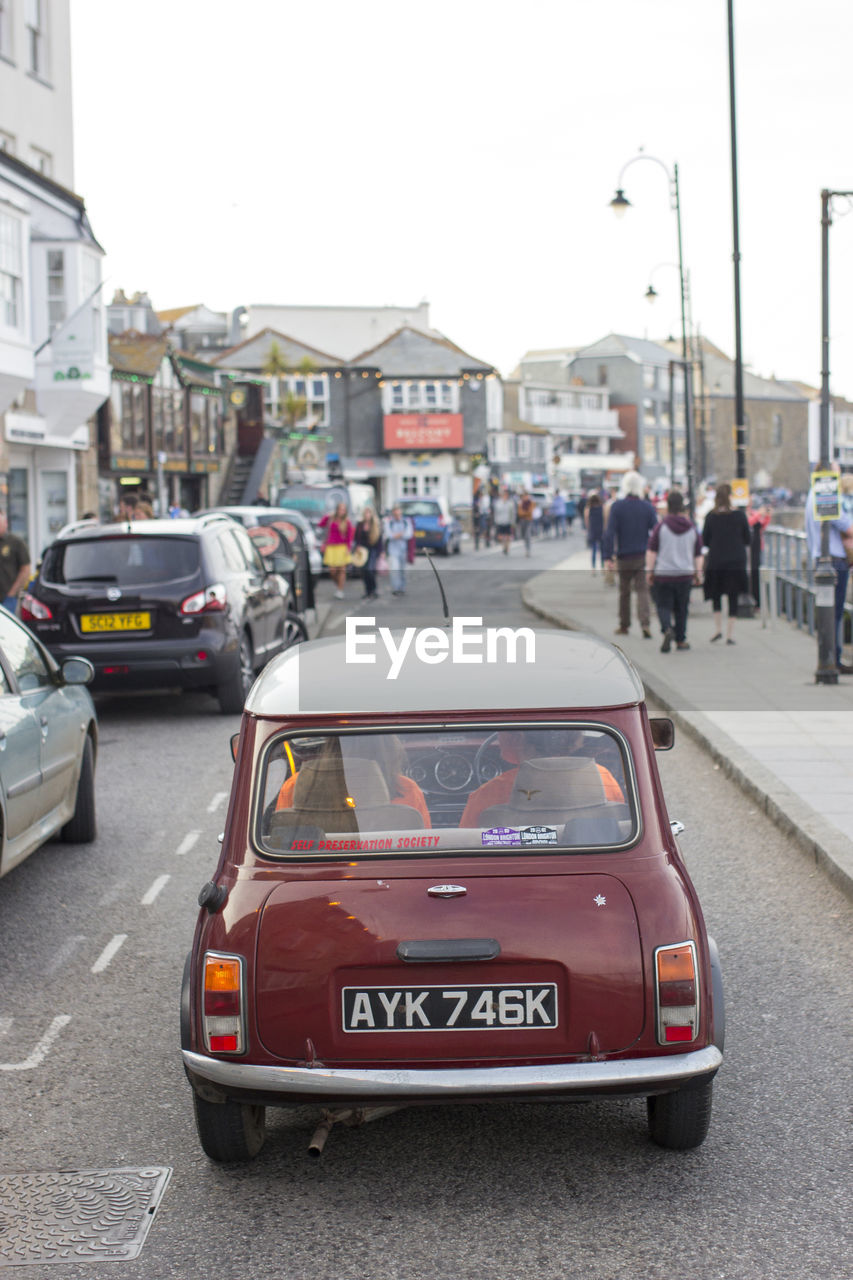 VEHICLES ON ROAD AGAINST BUILDINGS