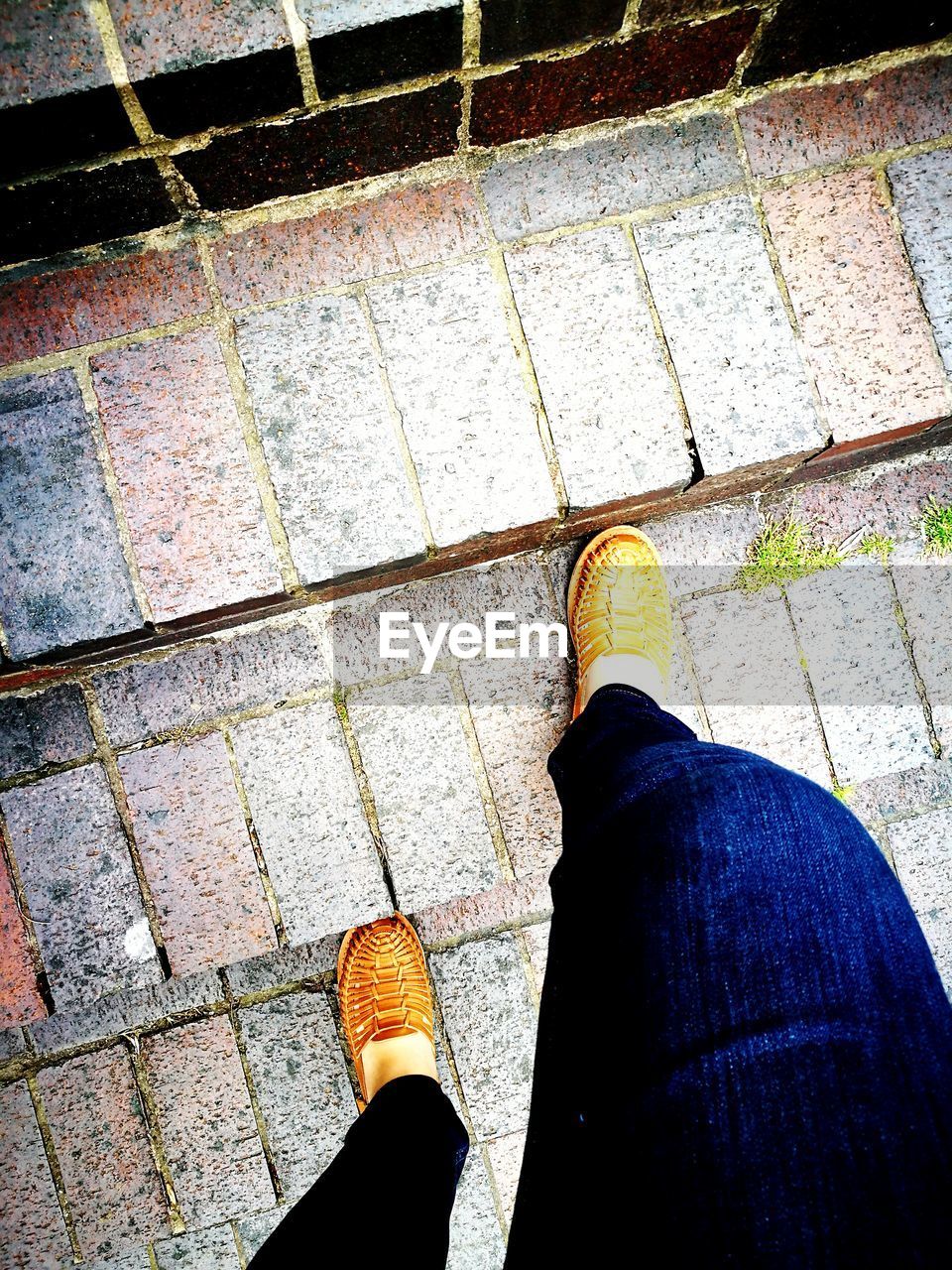 LOW SECTION OF PERSON STANDING ON TILED FLOOR