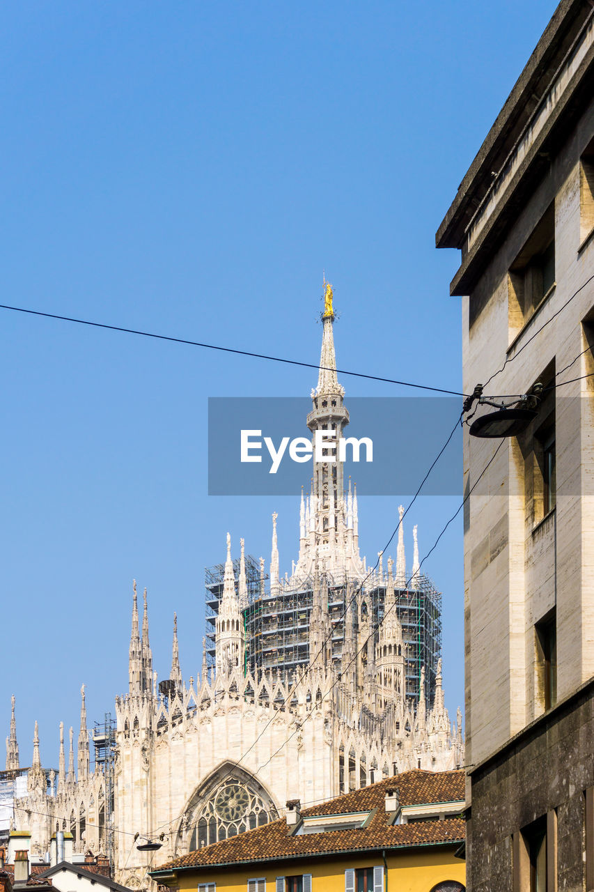 Low angle view of milan cathedral against clear blue sky