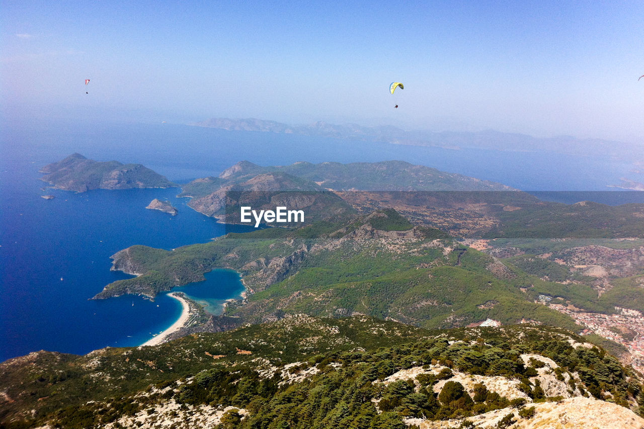 AERIAL VIEW OF SEA AND MOUNTAINS AGAINST SKY