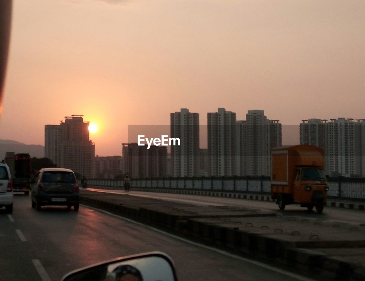 CARS ON ROAD AGAINST SKY DURING SUNSET