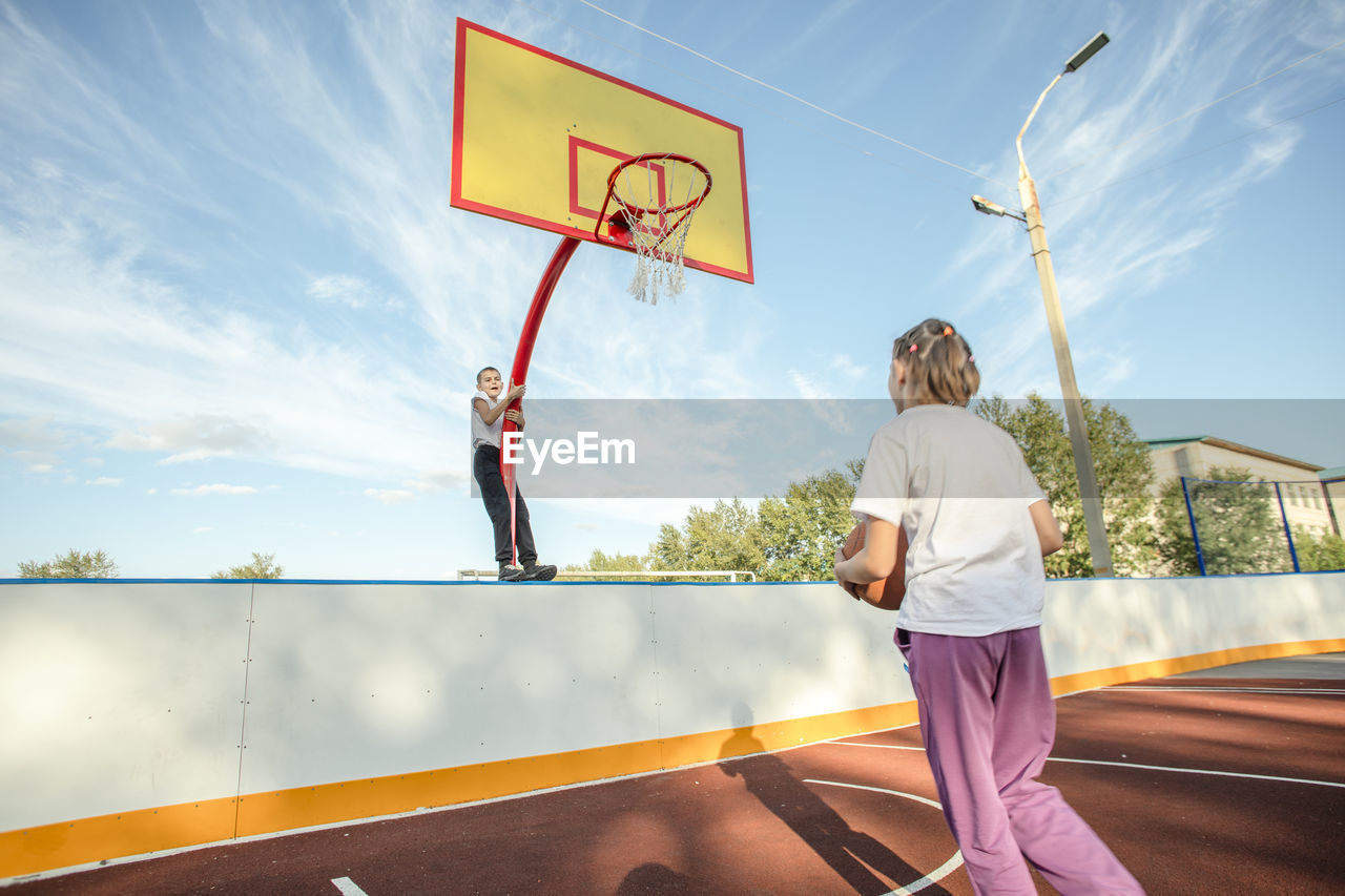 Game of glances, girl's basketball focus captivated by boy's daring hoop feats