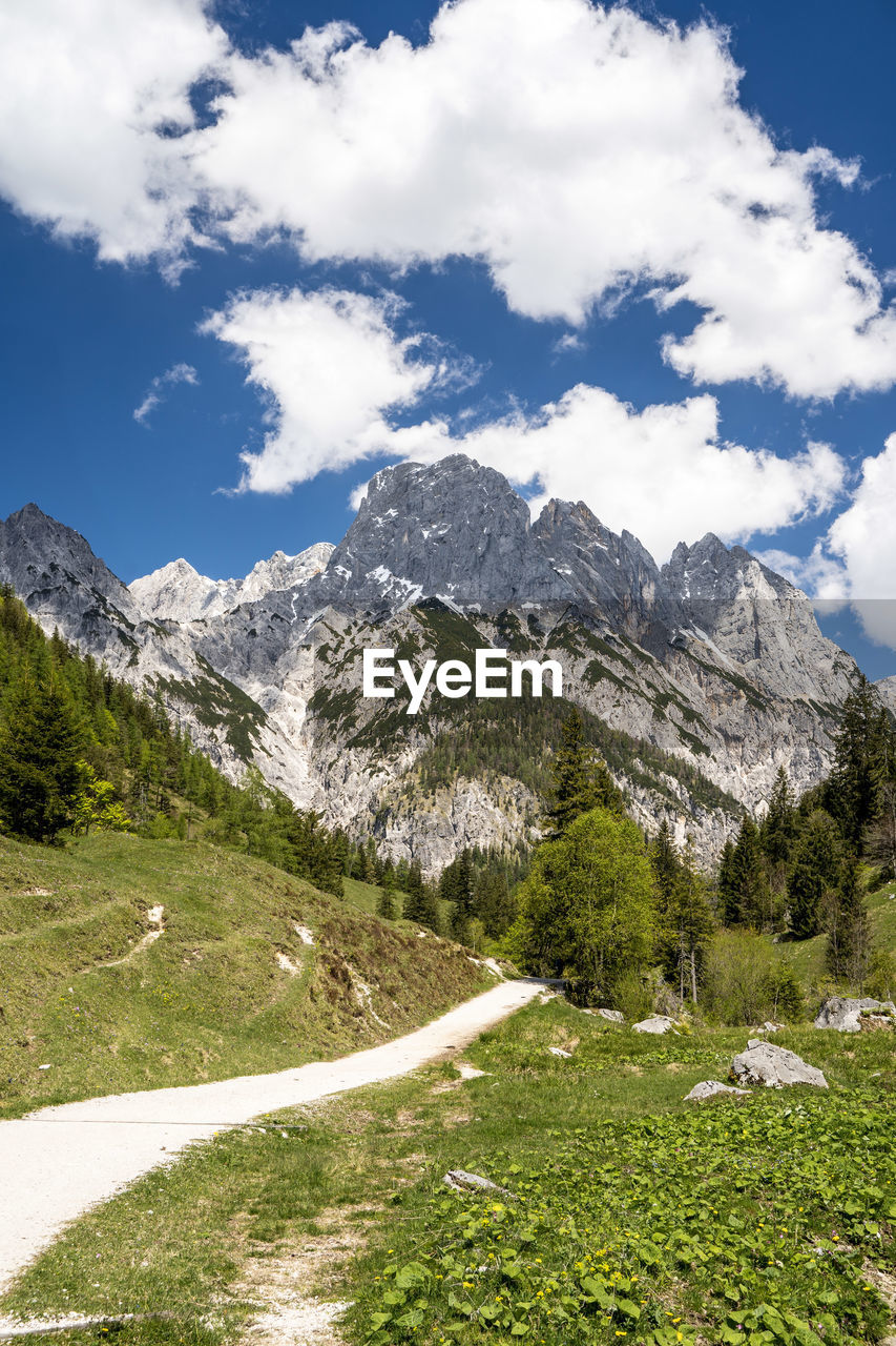 Scenic view of road by mountains against sky