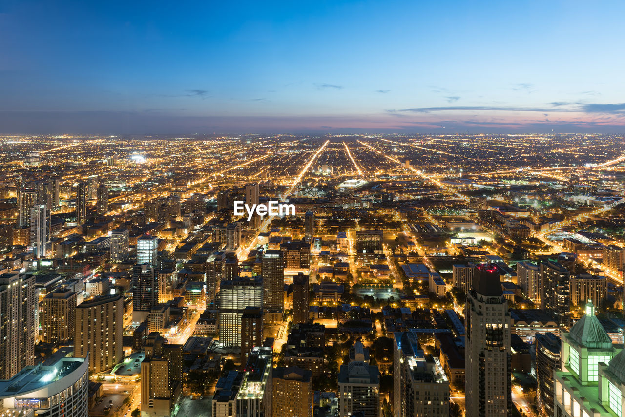 High angle view of city lit up at night