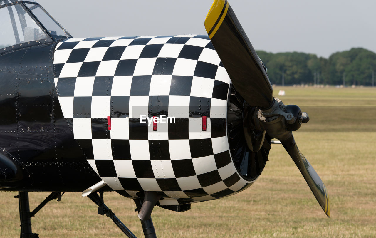 CLOSE-UP OF UMBRELLA AGAINST FIELD