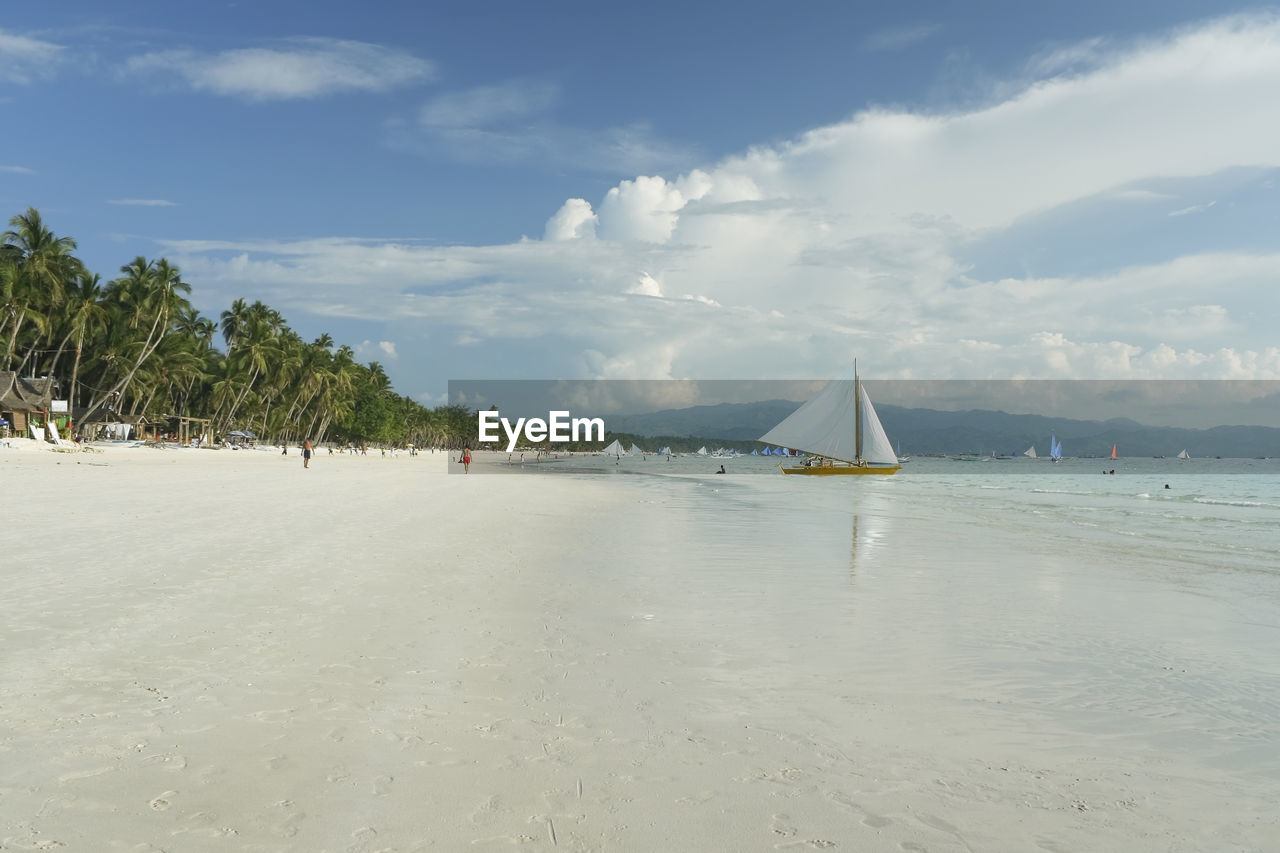 Sailboat on beach against sky