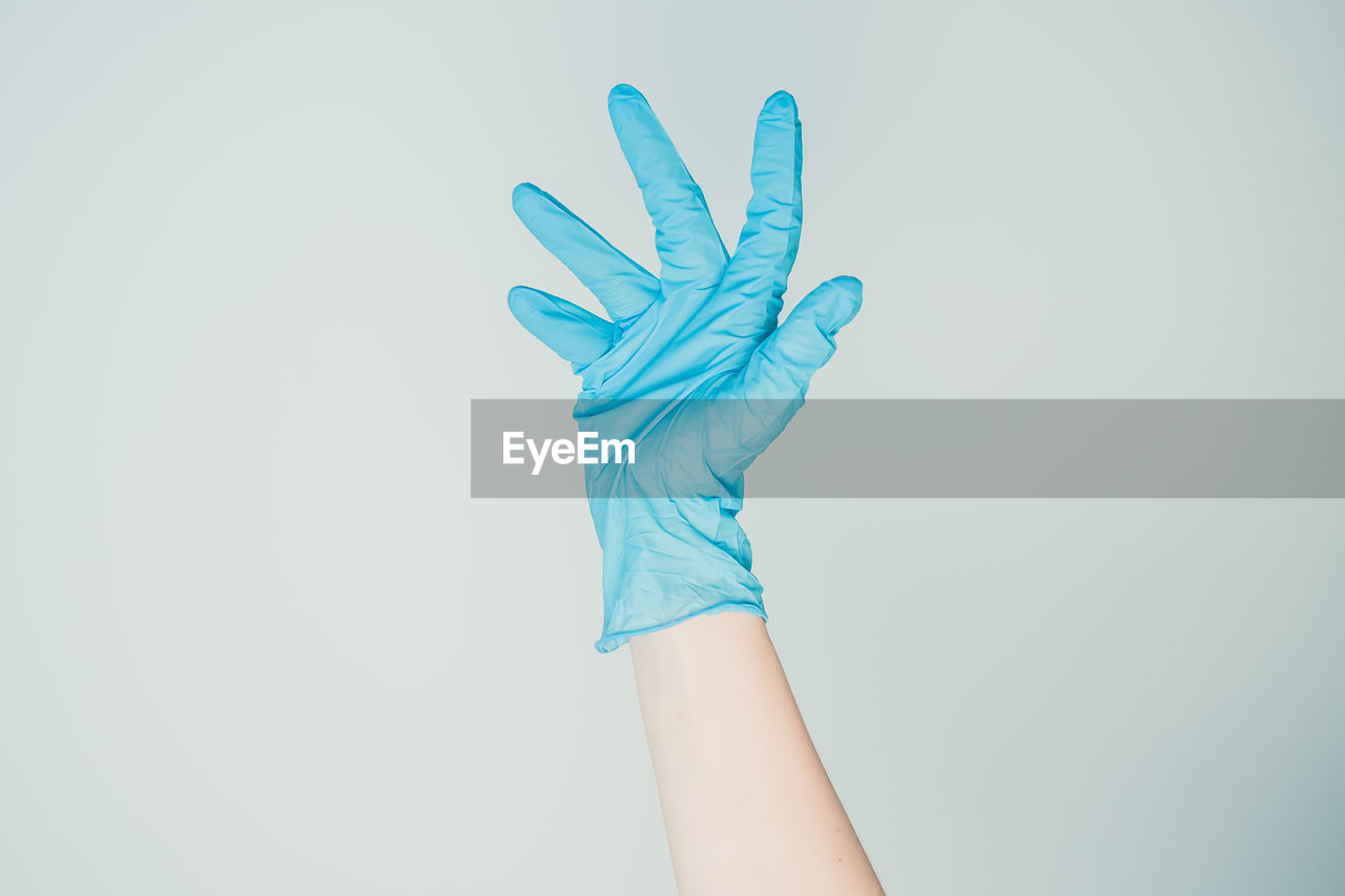 Women's hand wearing medical gloves