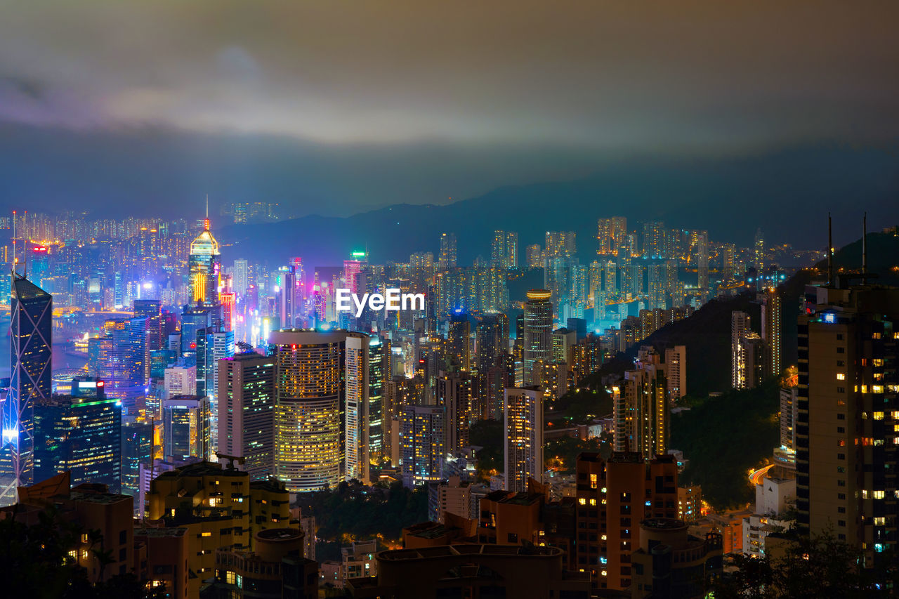 Illuminated cityscape against sky at night