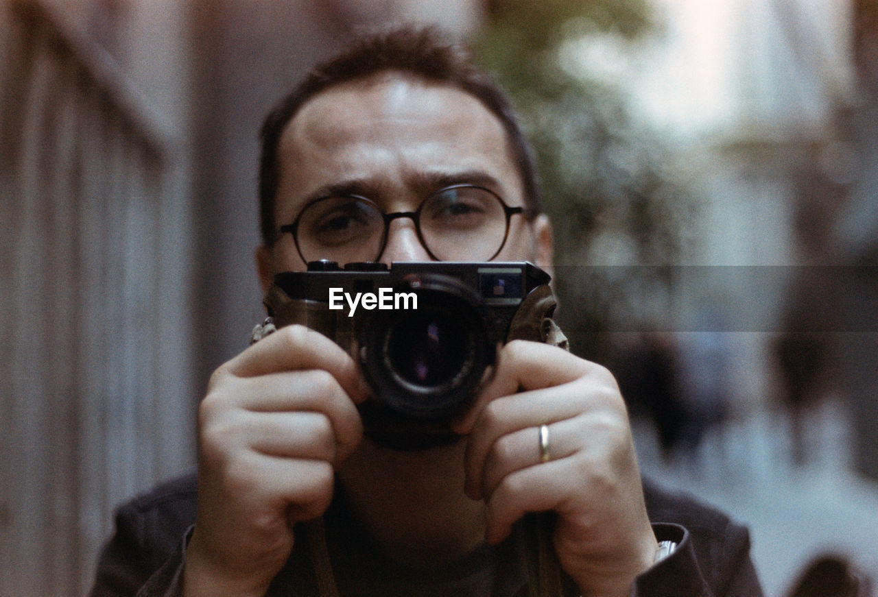 Portrait of man photographing outdoors