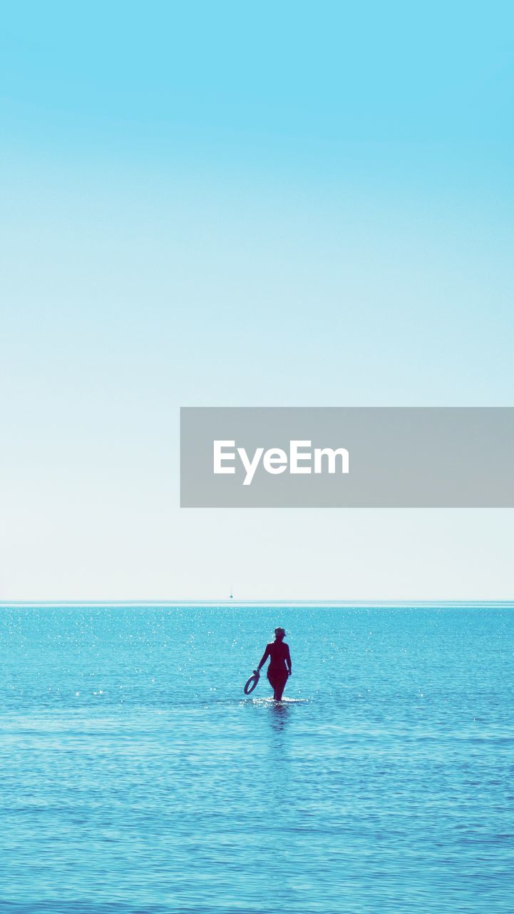 MAN ON SEA AGAINST CLEAR BLUE SKY