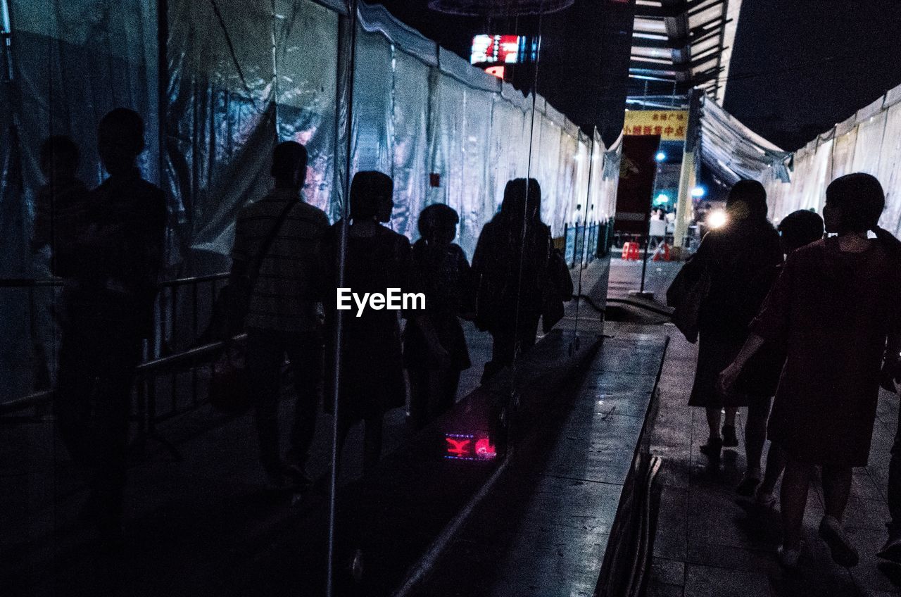 PEOPLE WALKING ON STREET AT NIGHT