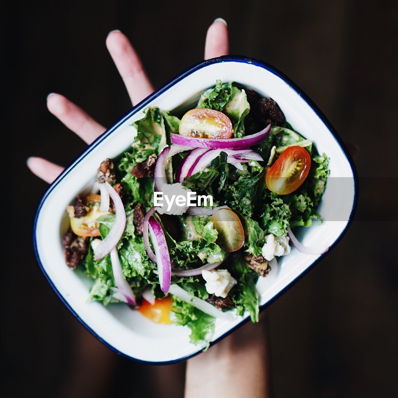 Cropped image of hand holding salad plate