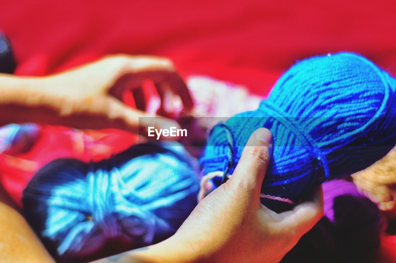 Cropped image of hand holding wool ball