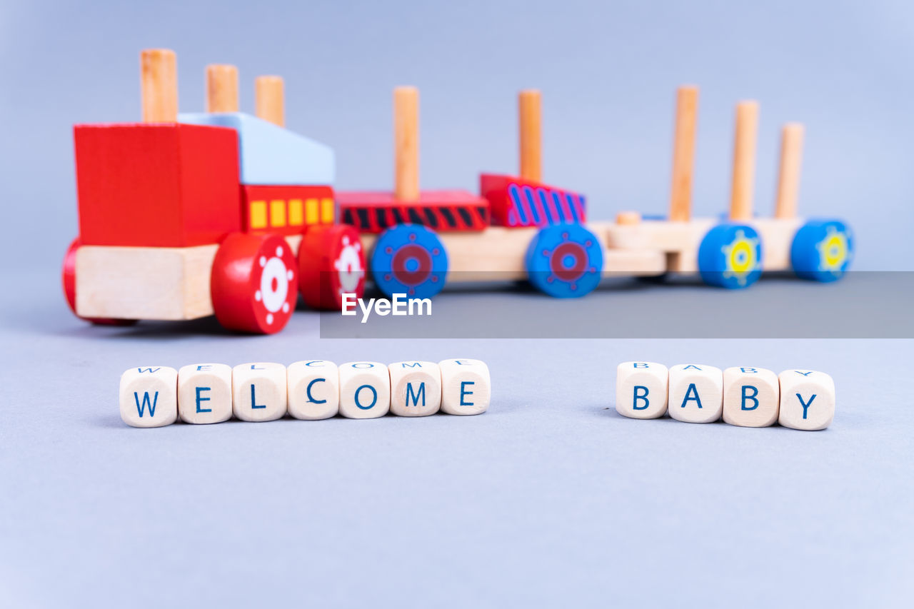 Close-up of beads with text by toy train on table