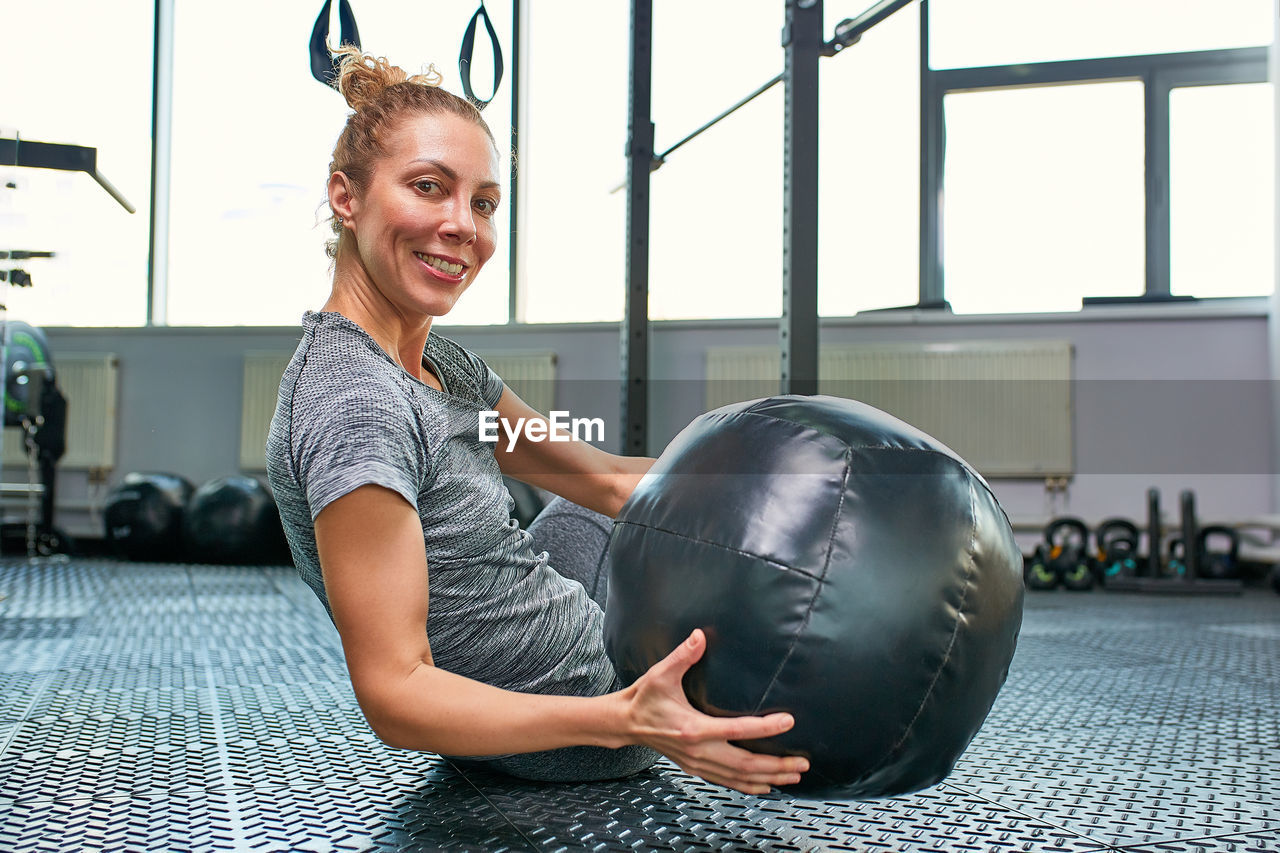 Portrait of young woman exercising in gym