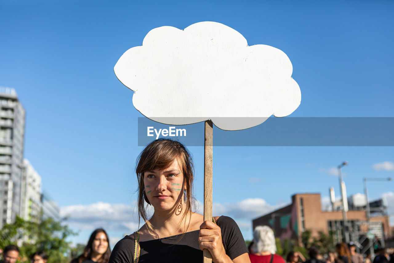 PORTRAIT OF SMILING WOMAN AGAINST SKY