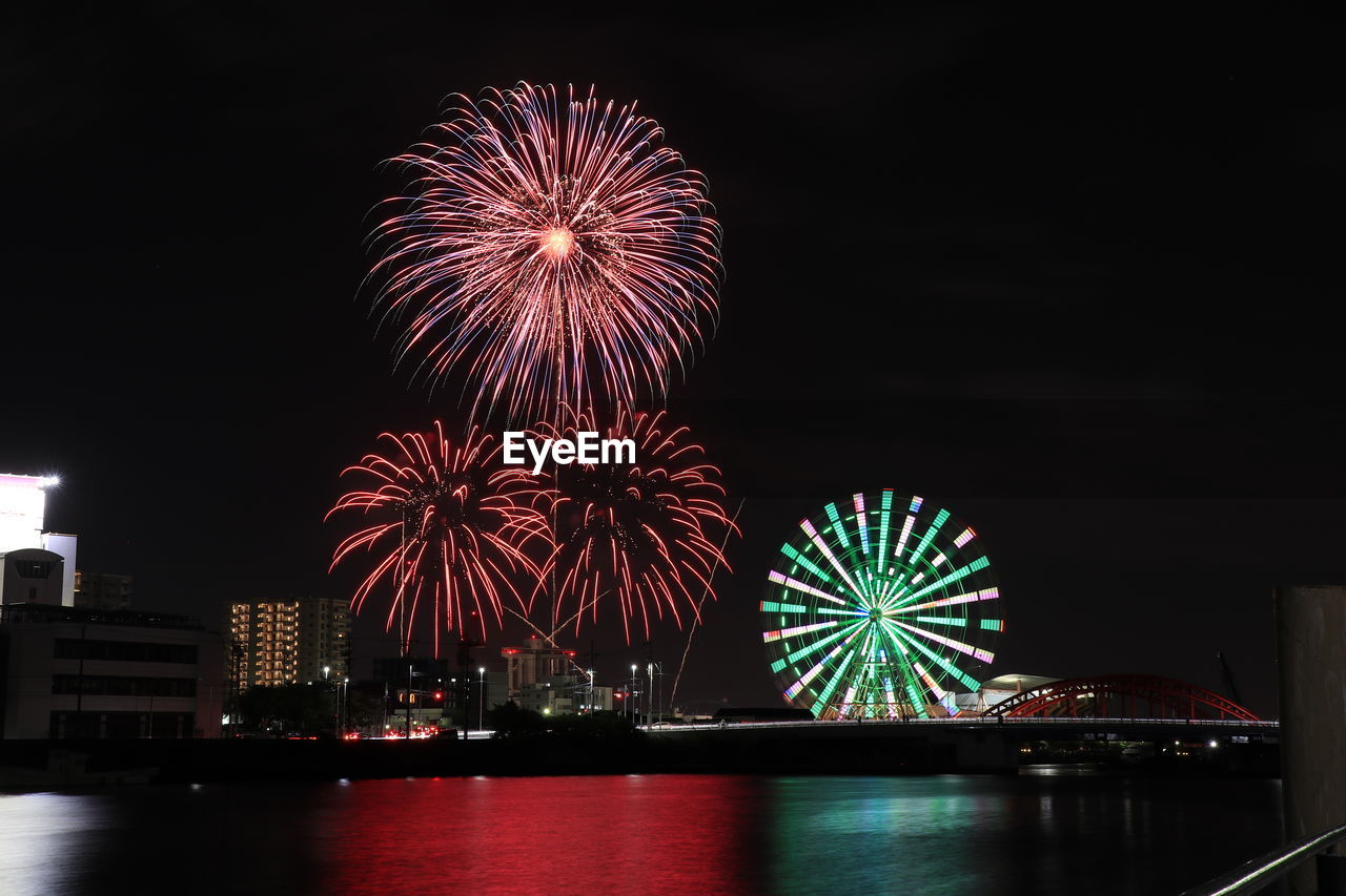 Firework display over river at night