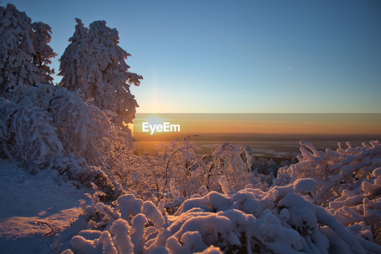 SCENIC VIEW OF SNOW COVERED LANDSCAPE DURING SUNSET