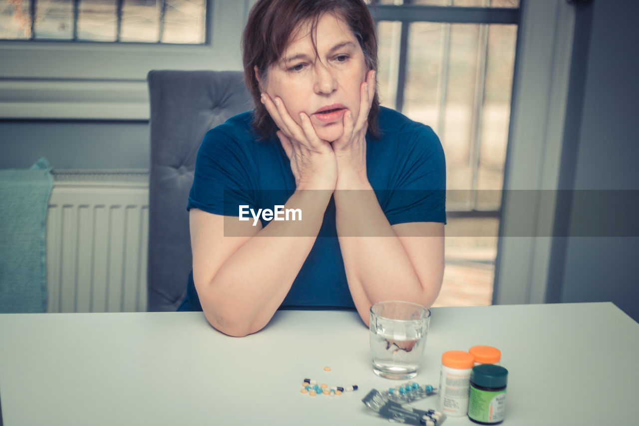 PORTRAIT OF A WOMAN SITTING ON TABLE