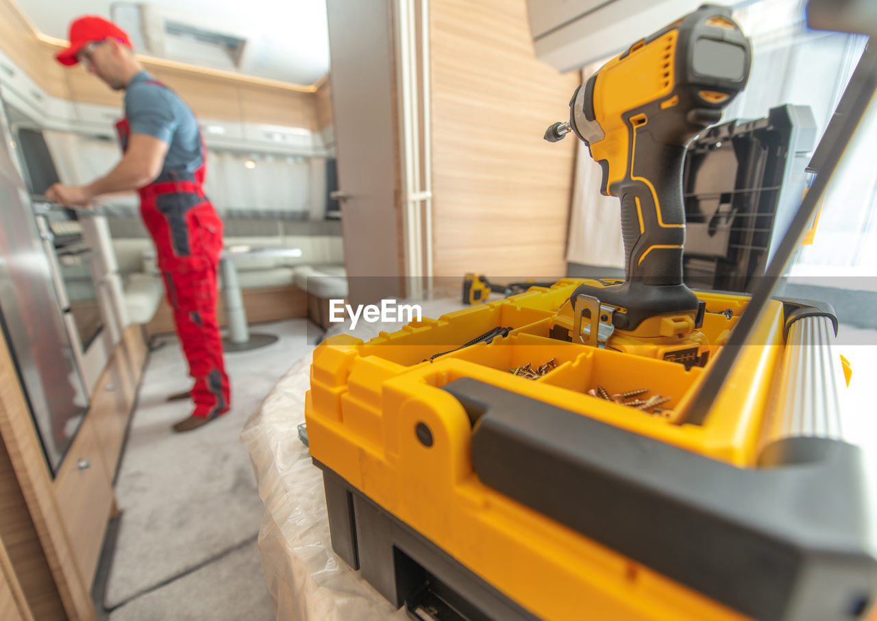 Close-up of tool with man working in background