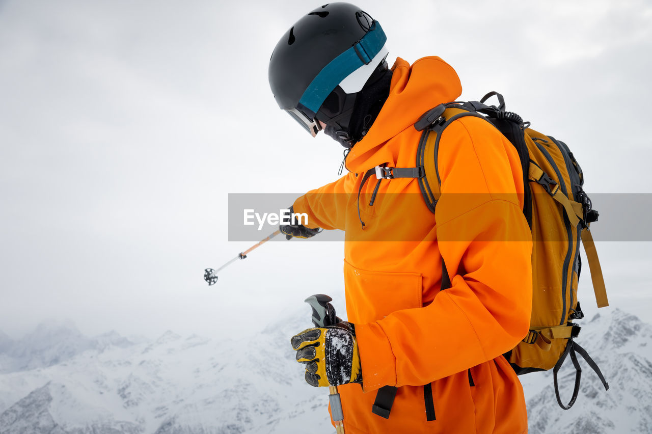 Portrait of a young adult in a ski helmet and goggles, with high