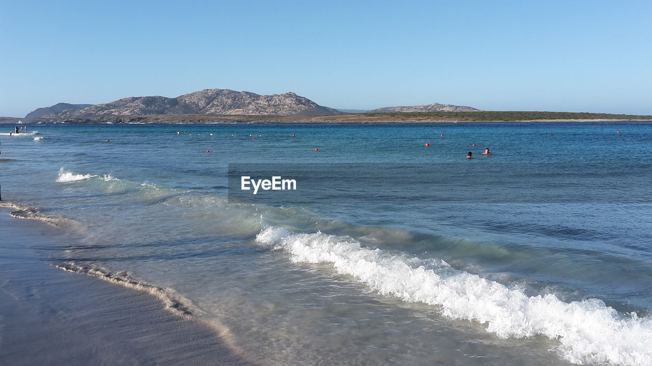 SCENIC VIEW OF SEA AND MOUNTAINS AGAINST CLEAR BLUE SKY