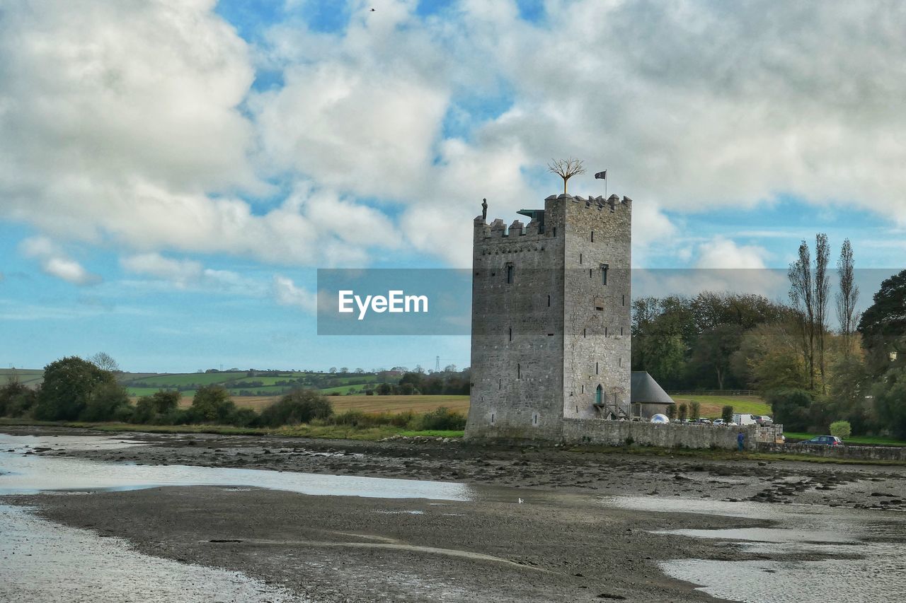 architecture, sky, cloud, built structure, tower, history, sea, the past, building exterior, water, nature, building, coast, travel destinations, land, travel, castle, no people, day, beach, landscape, outdoors, fort, environment, tourism, tree, plant, shore, old