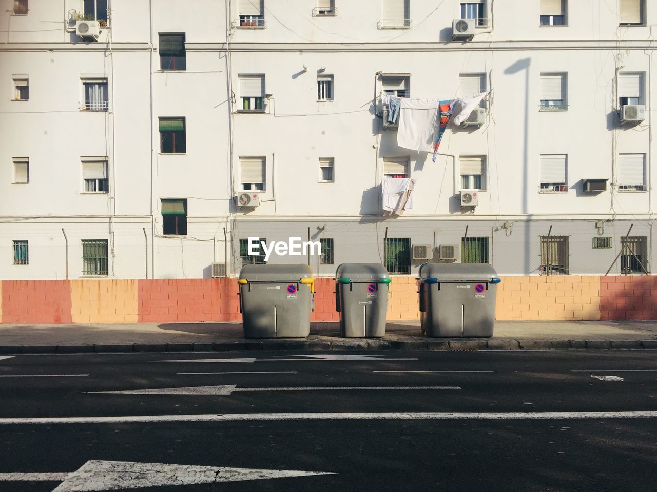 Garbage bin on street against buildings in city