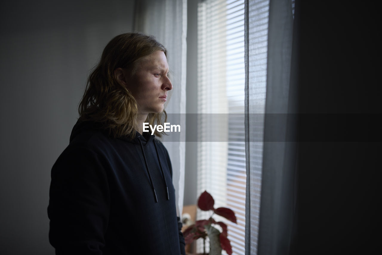 Sad woman looking through window