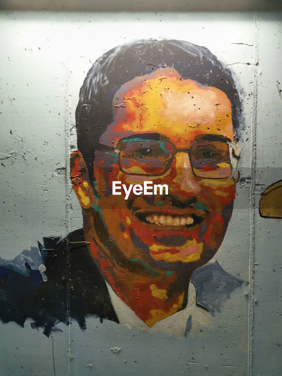 CLOSE-UP PORTRAIT OF SMILING MAN WITH MULTI COLORED UMBRELLA