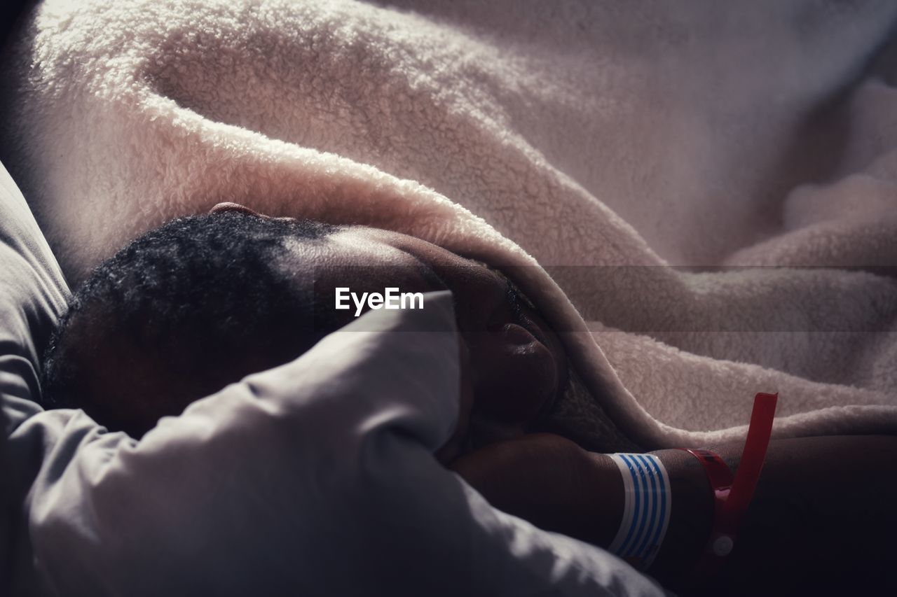 High angle view of man resting on bed after medical procedure 