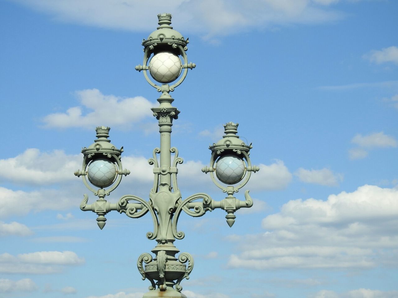 Low angle view of street light against cloudy sky