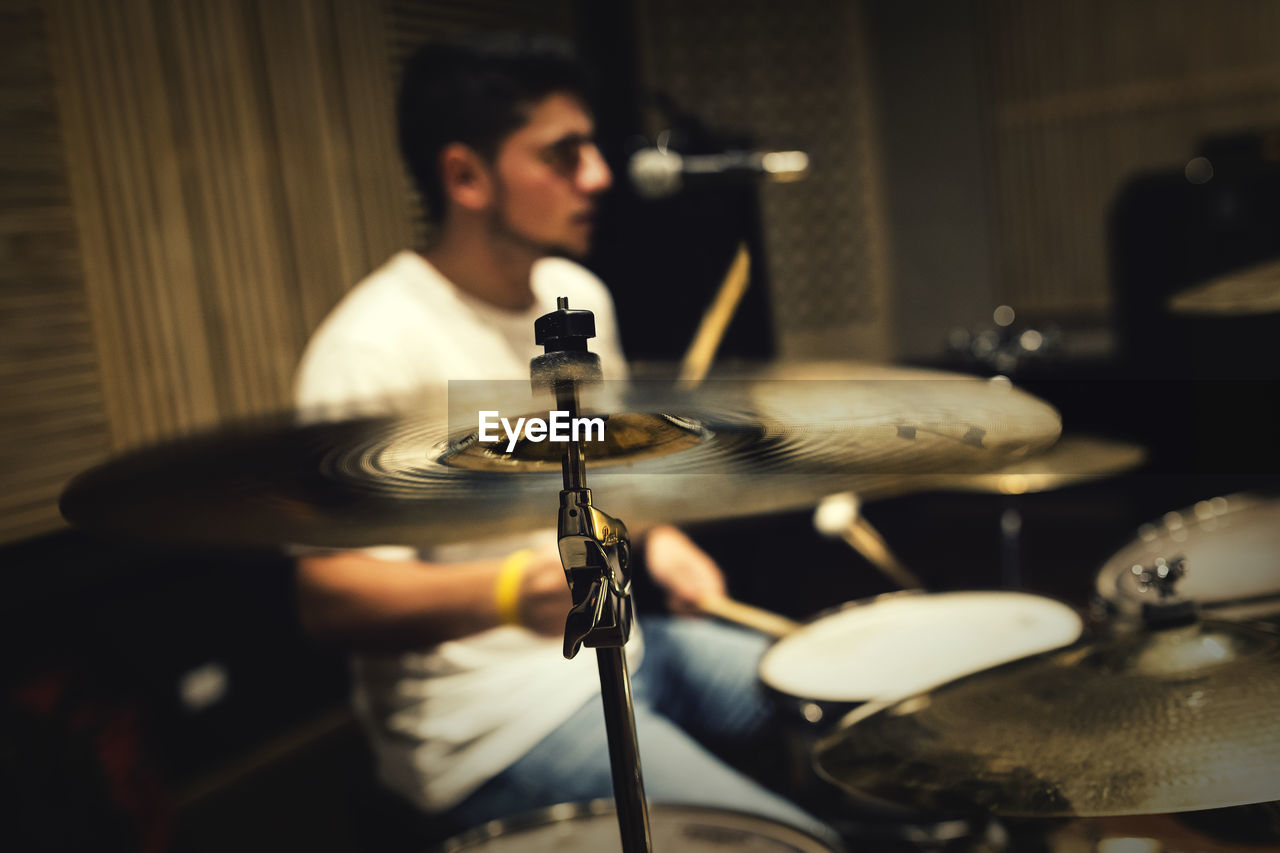 Close-up of man playing drum in darkroom