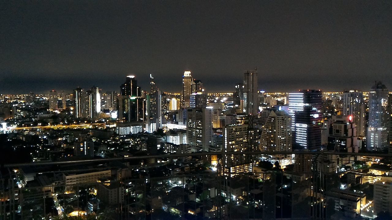 Illuminated cityscape against sky at night