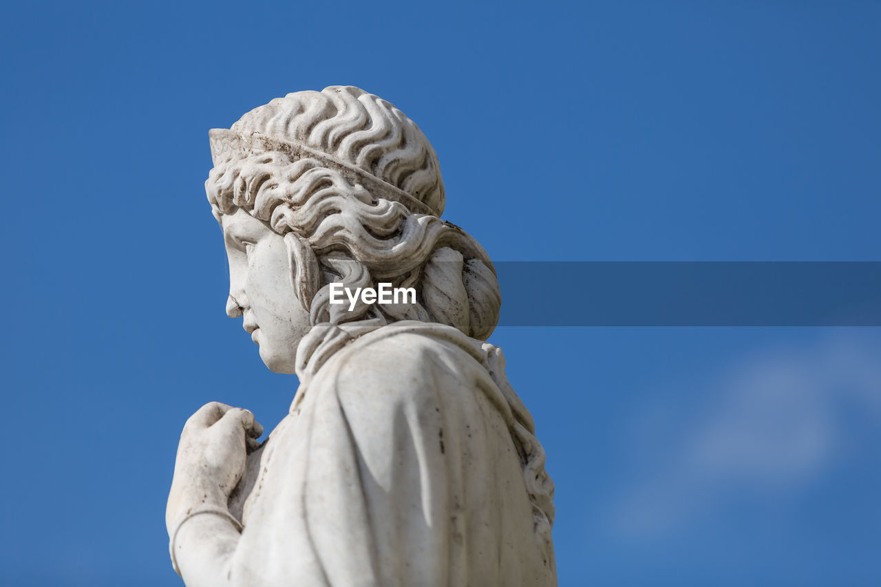 Low angle view of statue against blue sky