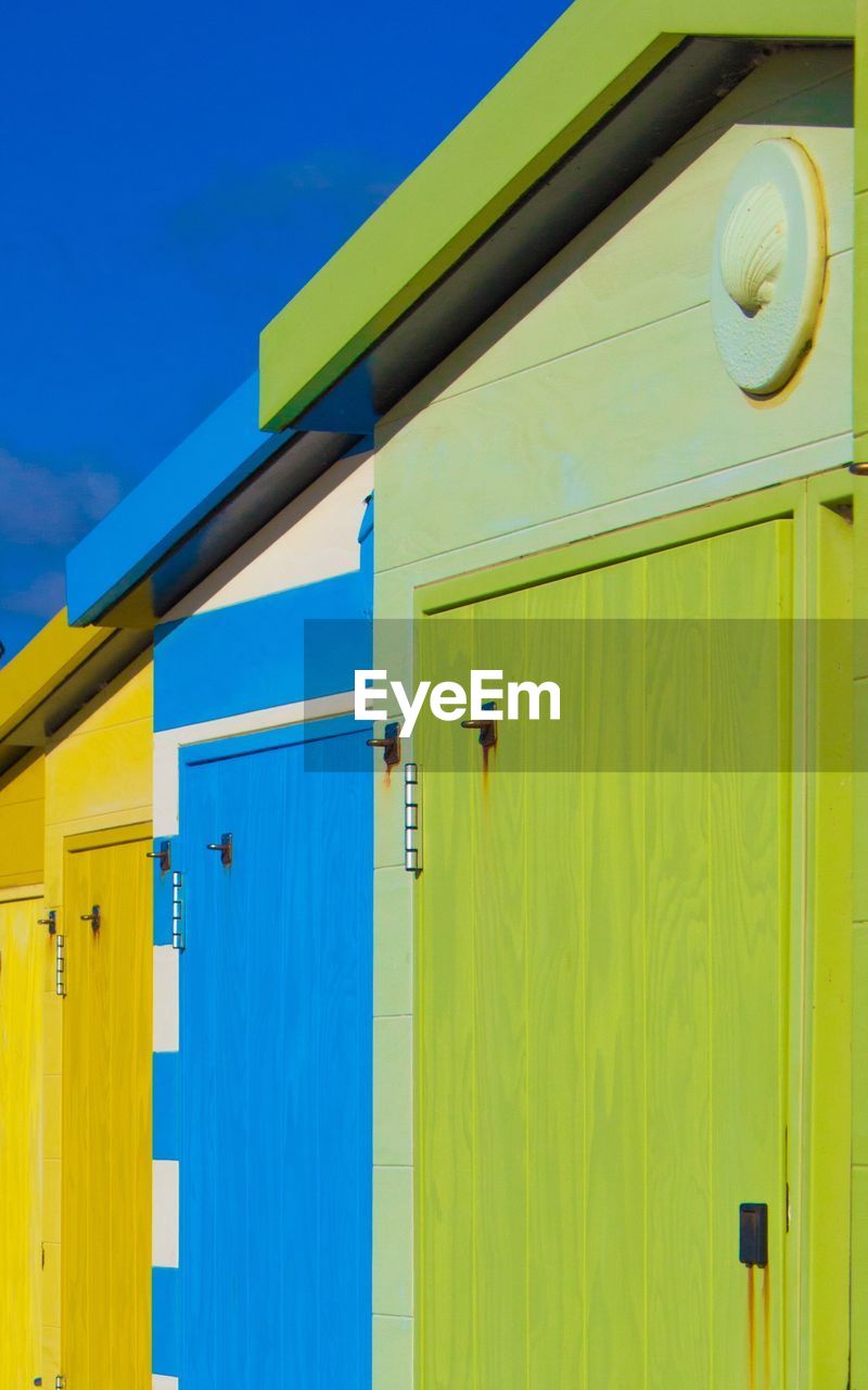 Low angle view of multi colored beach hut against sky