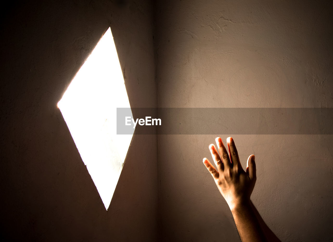 Close-up of praying hand holding illuminated light