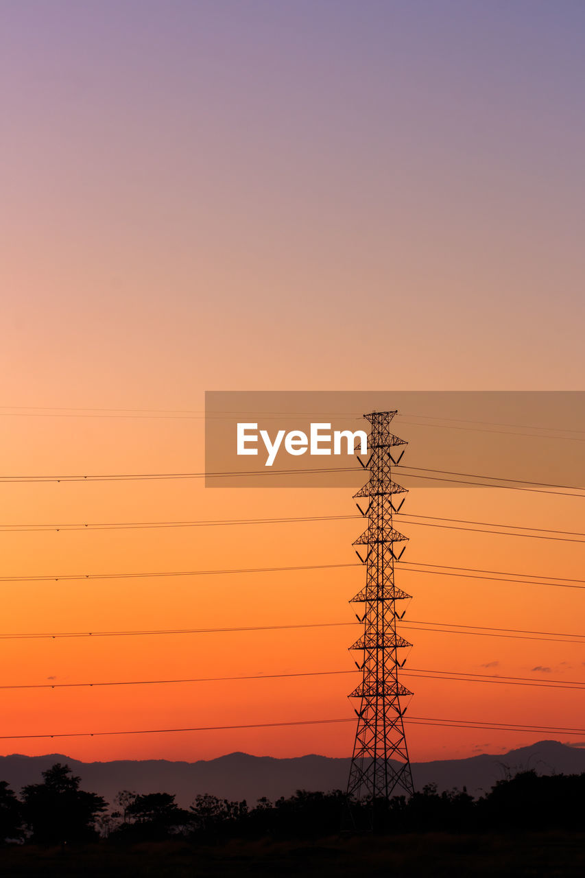 LOW ANGLE VIEW OF ELECTRICITY PYLON AGAINST ROMANTIC SKY AT SUNSET