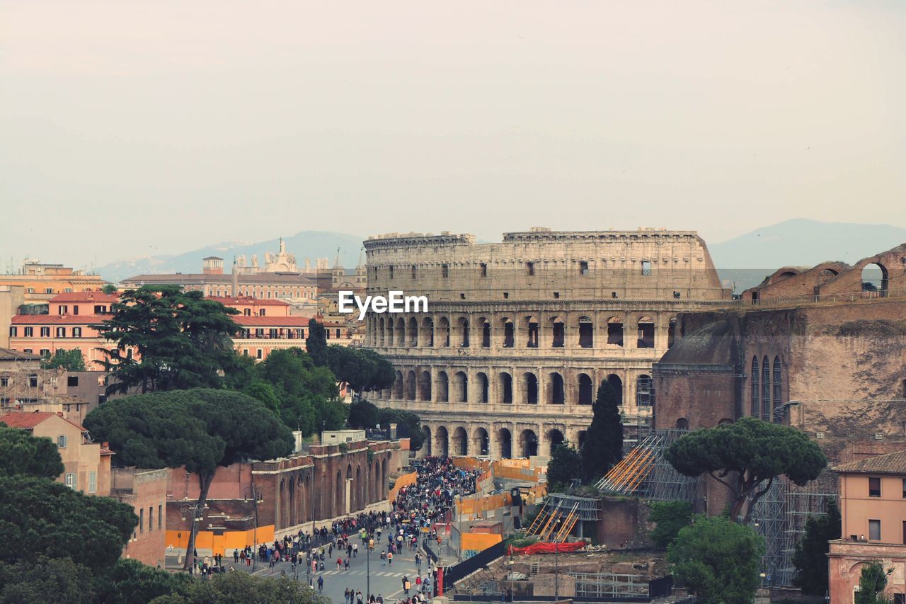 Coliseum in city against sky