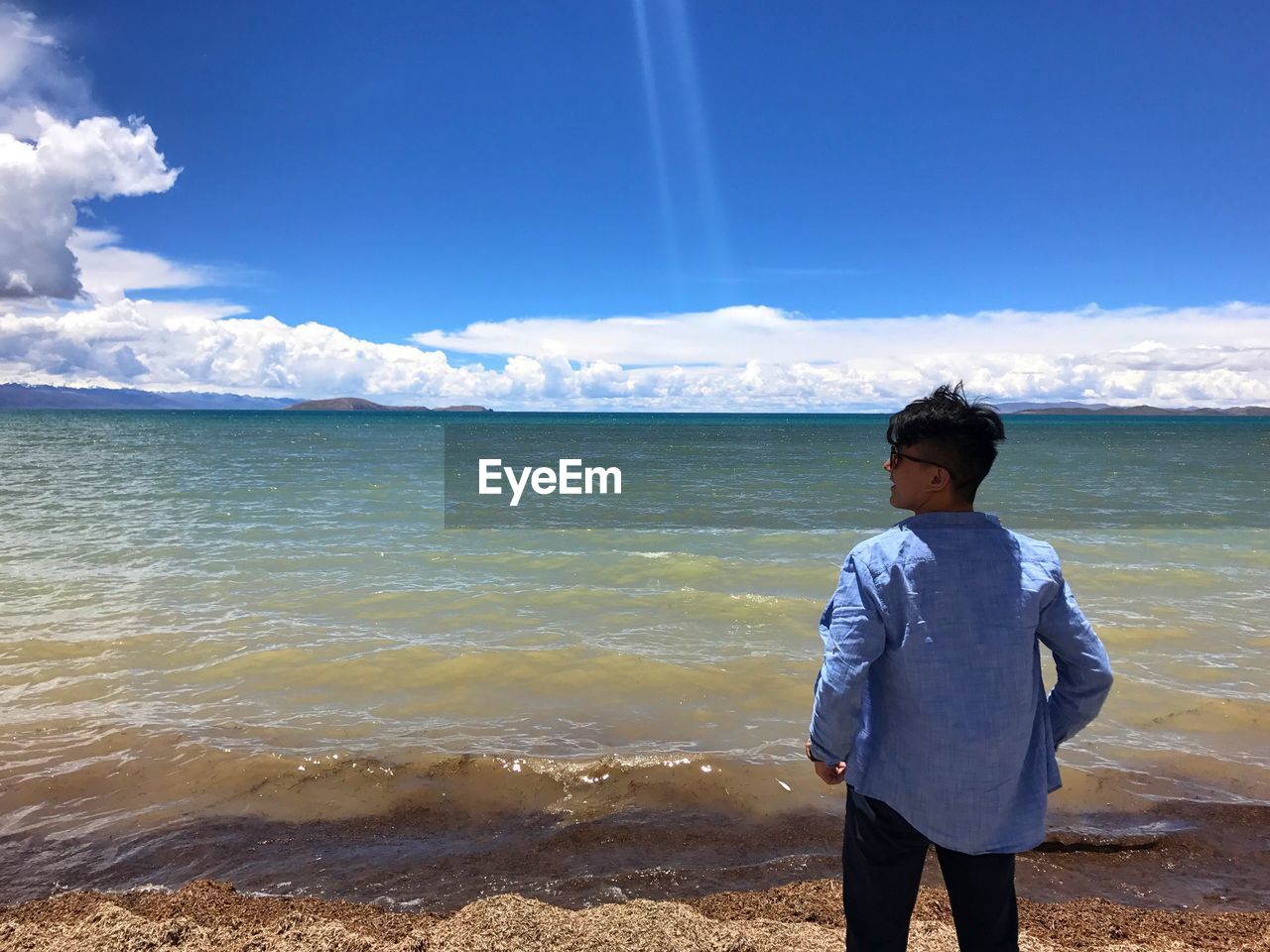 Rear view of man standing at beach